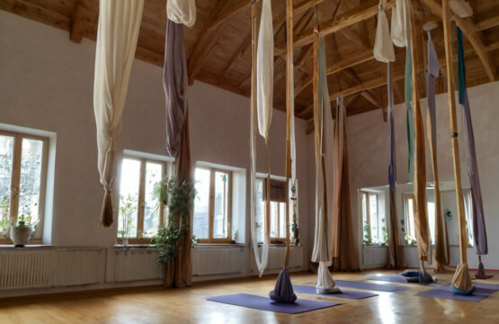 In einem Yoga Studio hängen Tücher für Aerial Yoga von der Decke.